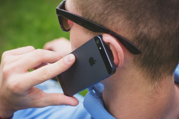 En ung man talar i en mobiltelefon