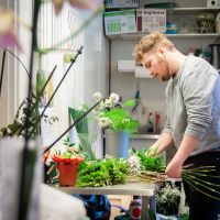 en man gör blomsterarrangemang