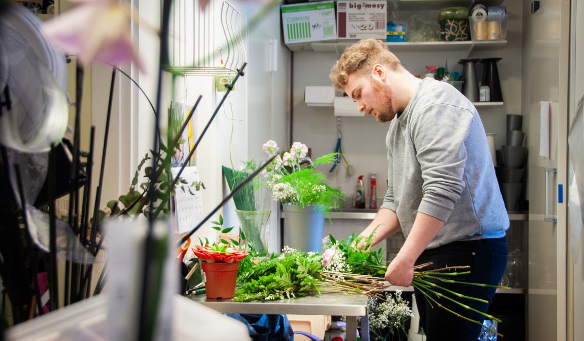 en man gör blomsterarrangemang