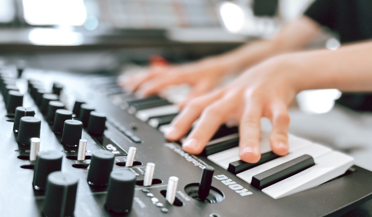 Bild på händer som spelar på en synth