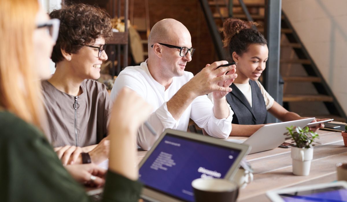 Blandad grupp personer som sitter vid ett konferransbord
