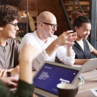 Blandad grupp personer som sitter vid ett konferransbord