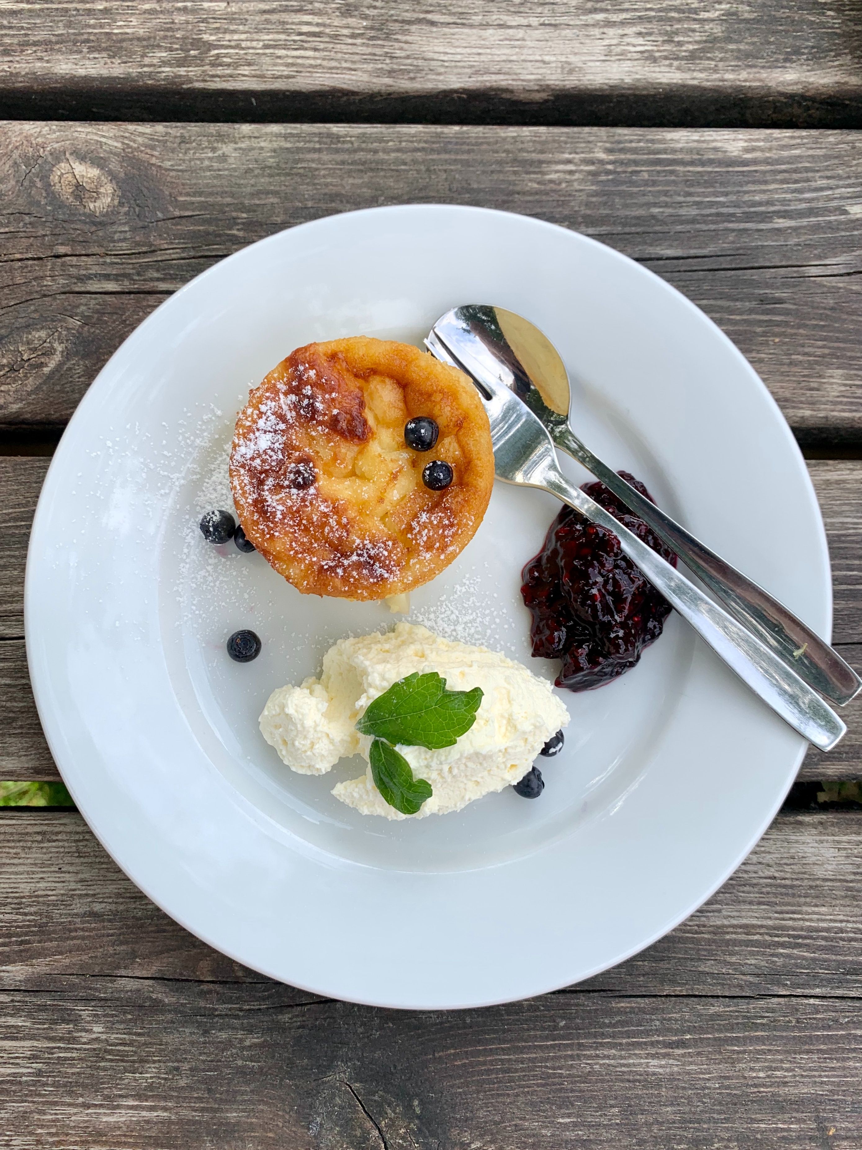 Bild på en dessert på en vit tallrik. Bakgrund en gråa plankor.